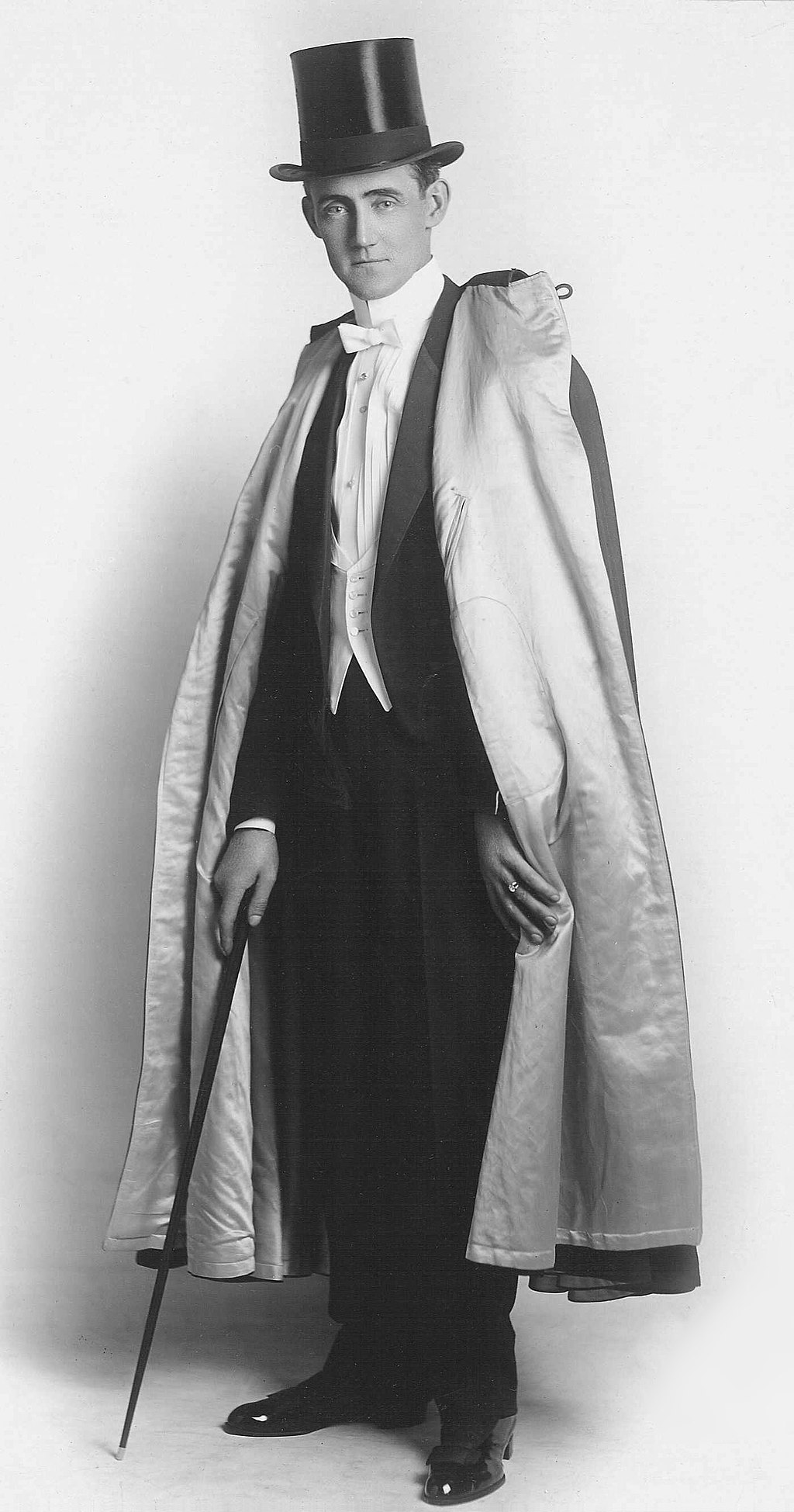 Full-length photograph of Claude Alexander Conlin in top hat, cape and cane
