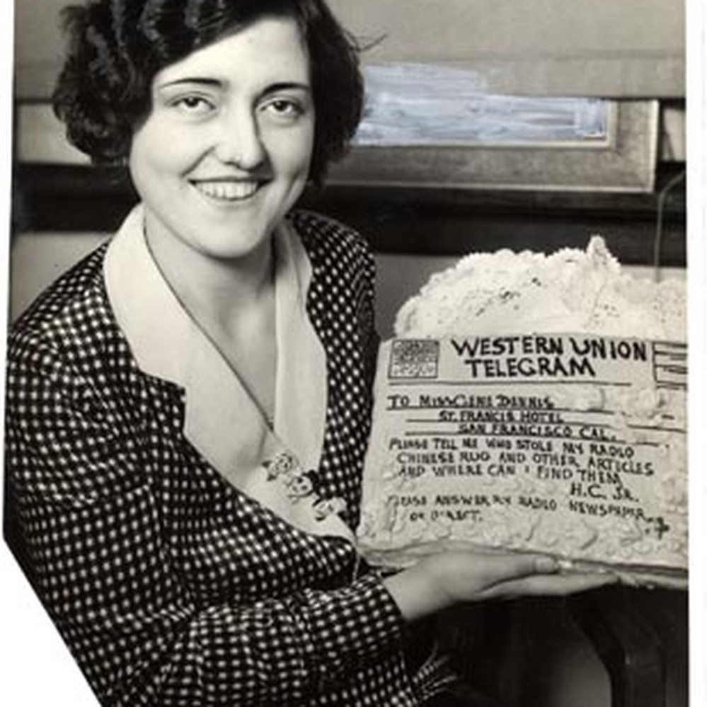 Gene Dennis holding a cake iced as a Western Union telegram